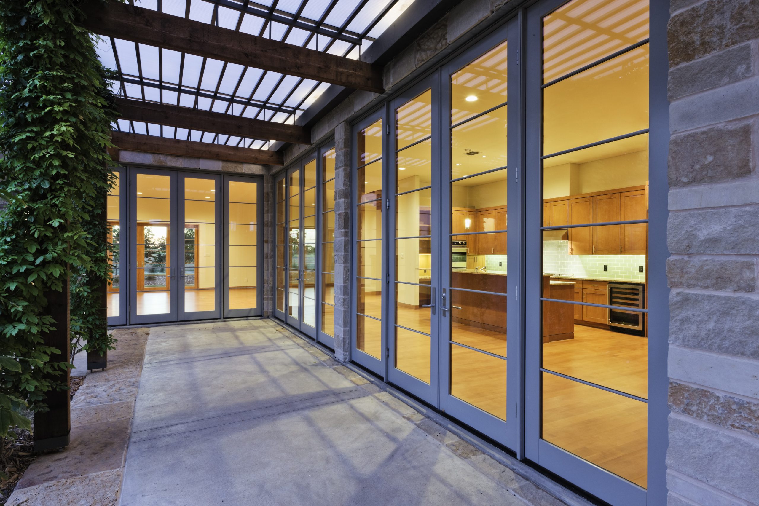 Row of glazed doors opening onto a covered patio